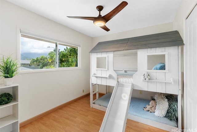 bedroom with baseboards, light wood-style floors, and a ceiling fan