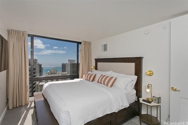 carpeted bedroom with visible vents and a city view