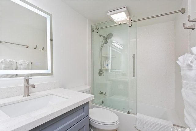 bathroom featuring vanity, toilet, and shower / bath combination with glass door