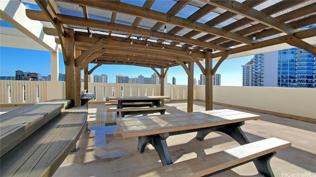 view of patio / terrace with a city view, outdoor dining space, and a pergola