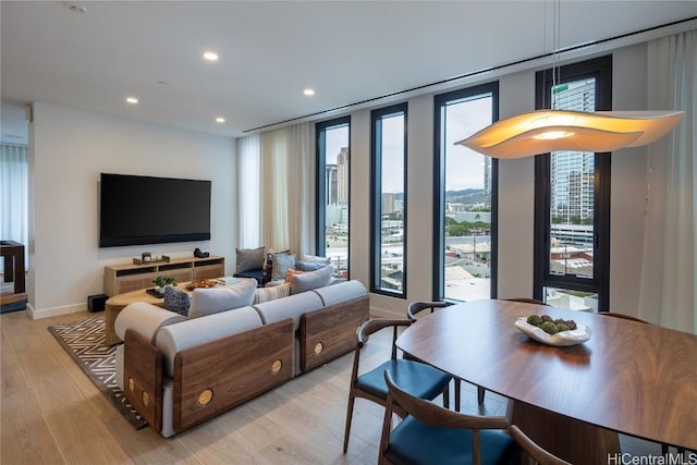 living room featuring recessed lighting, baseboards, and light wood finished floors