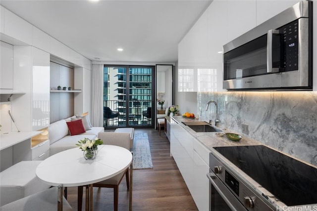 kitchen with stainless steel microwave, white cabinetry, modern cabinets, and a sink