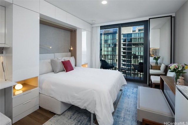 bedroom featuring expansive windows, wood finished floors, and access to exterior