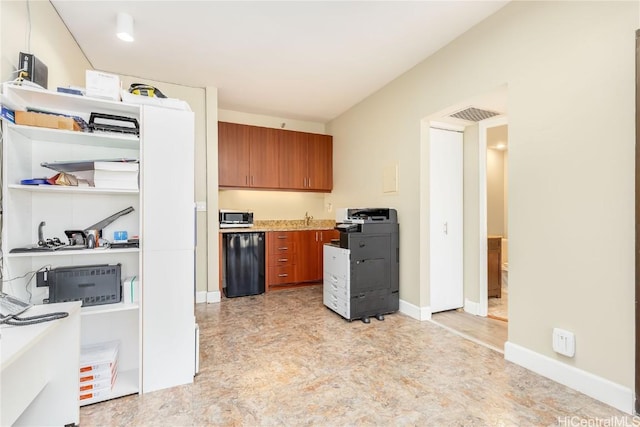 kitchen featuring gas range oven, brown cabinetry, visible vents, and baseboards