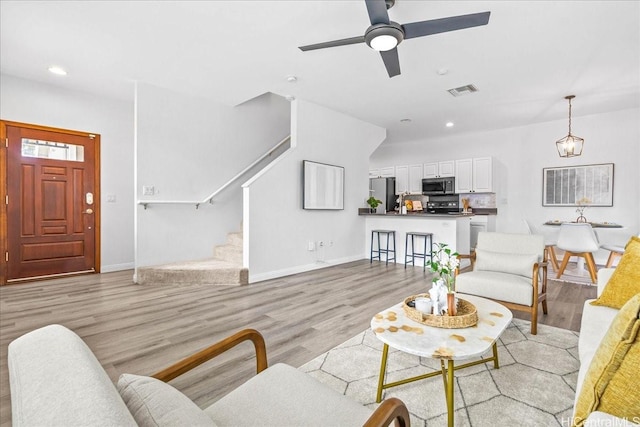 91-6221 Kapolei Pkwy Unit 201, Ewa Beach, HI 96706 - living area with stairs, light wood-style flooring, baseboards, recessed lighting, and a ceiling fan