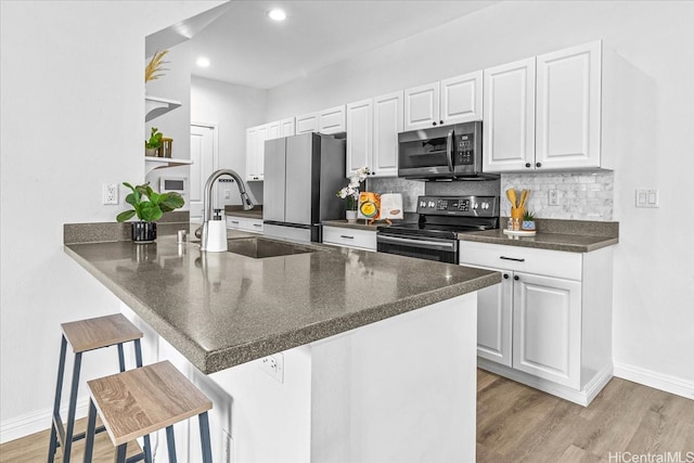 91-6221 Kapolei Pkwy Unit 201, Ewa Beach, HI 96706 - kitchen with appliances with stainless steel finishes, a sink, dark countertops, a kitchen breakfast bar, and baseboards