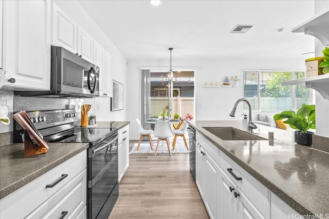 91-6221 Kapolei Pkwy Unit 201, Ewa Beach, HI 96706 - kitchen with appliances with stainless steel finishes, a sink, white cabinetry, light wood-style floors, and tasteful backsplash
