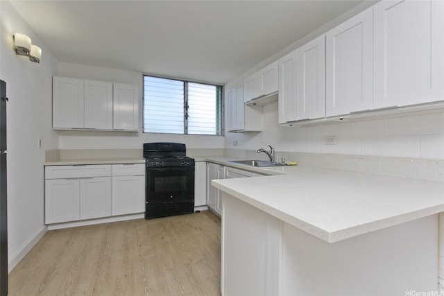 1118 Pua Ln Unit 301, Honolulu, HI 96817 - kitchen with a sink, black range with gas cooktop, light countertops, and white cabinets