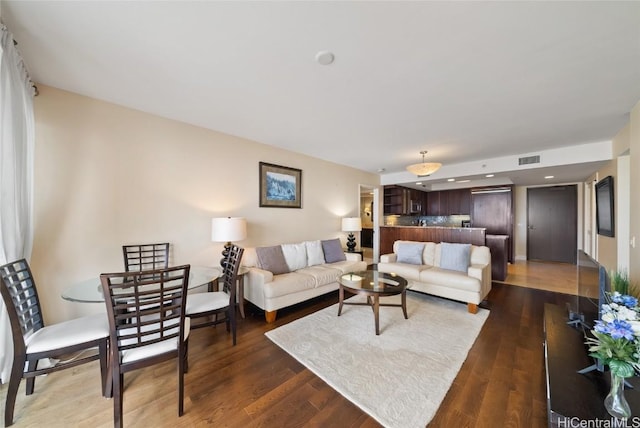 living room with visible vents, recessed lighting, and wood finished floors