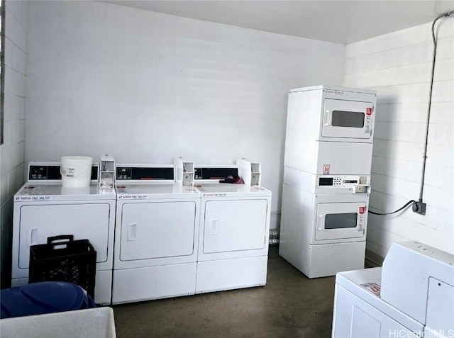 common laundry area featuring separate washer and dryer, stacked washer and clothes dryer, and concrete block wall