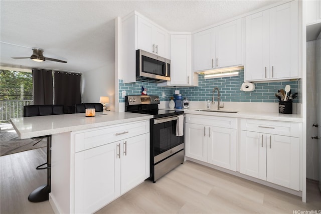 95-2027 Waikalani Pl Unit A404, Mililani, HI 96789 - kitchen with stainless steel appliances, decorative backsplash, a breakfast bar, light countertops, and a textured ceiling