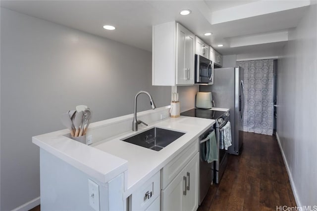 kitchen featuring a sink, appliances with stainless steel finishes, white cabinets, and recessed lighting