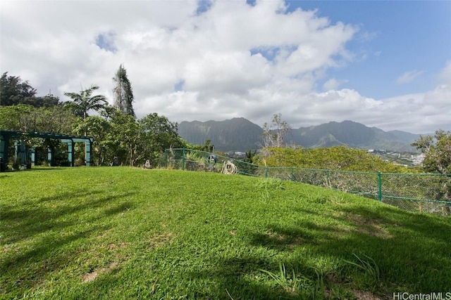 view of yard featuring a mountain view and fence