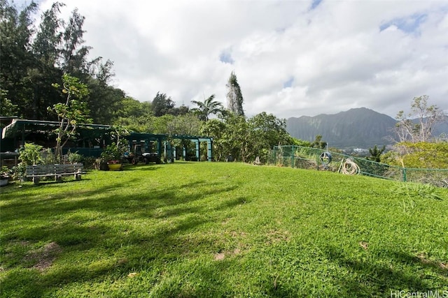 view of yard with a mountain view, a vegetable garden, and fence