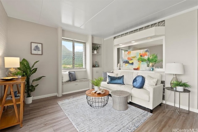 sitting room with baseboards and wood finished floors