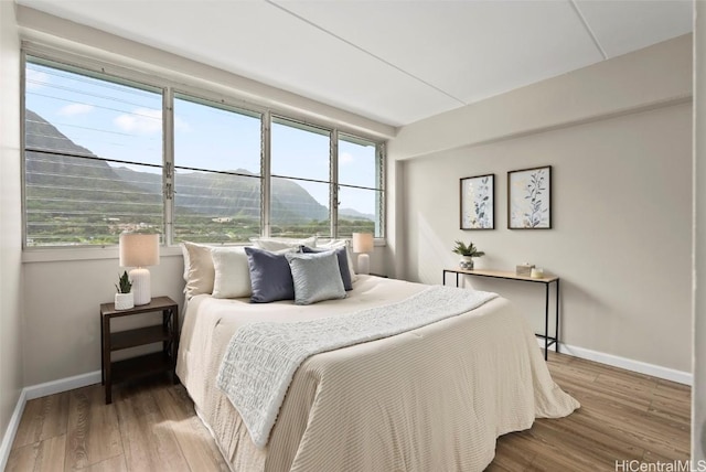 bedroom with baseboards and wood finished floors