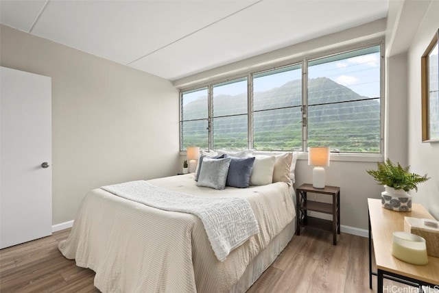 bedroom featuring baseboards and wood finished floors