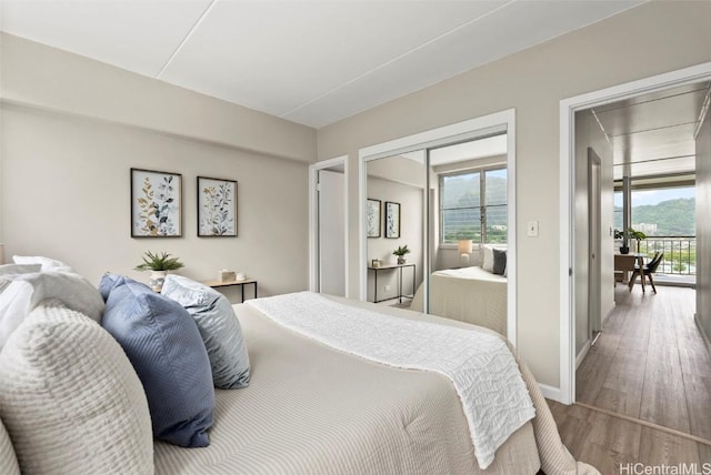 bedroom with a closet, baseboards, and wood finished floors