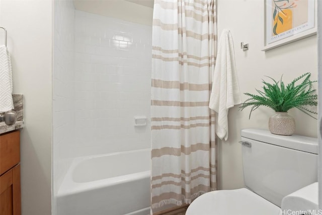 bathroom featuring vanity, shower / tub combo, and toilet