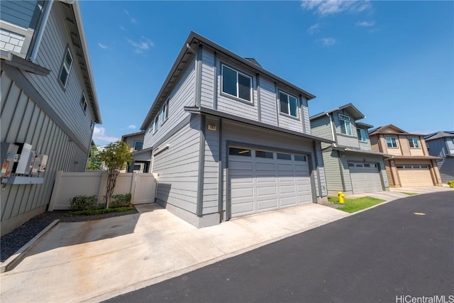 view of front of home featuring a residential view, an attached garage, driveway, and fence