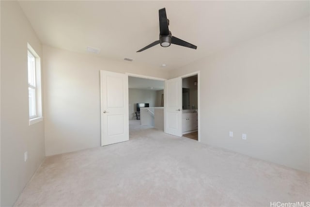 unfurnished bedroom featuring visible vents, a ceiling fan, and carpet