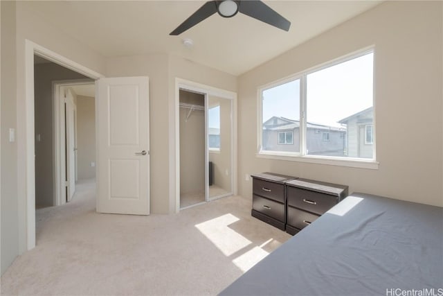 bedroom featuring light carpet, ceiling fan, and a closet