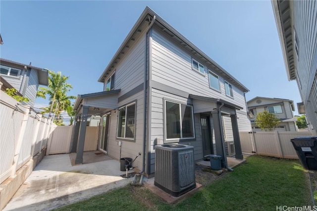 back of house featuring a patio, central AC unit, a lawn, and a fenced backyard