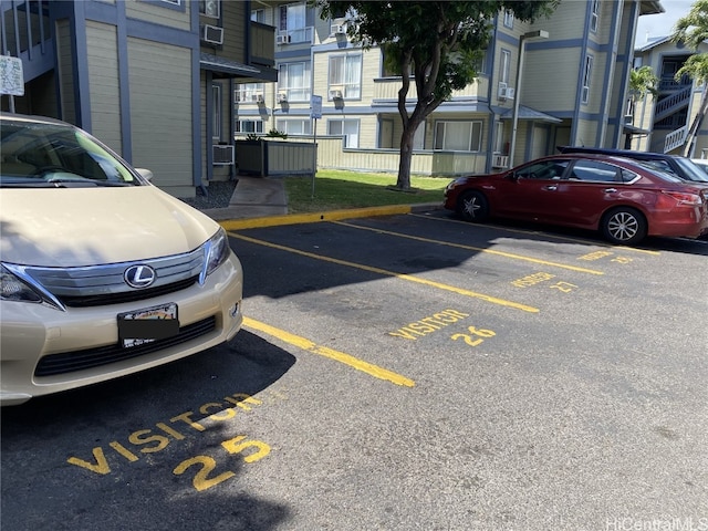 uncovered parking lot featuring cooling unit and a residential view