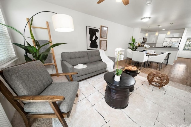 living area with light wood-type flooring and ceiling fan