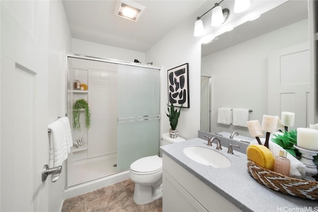 bathroom featuring visible vents, a shower stall, toilet, and vanity