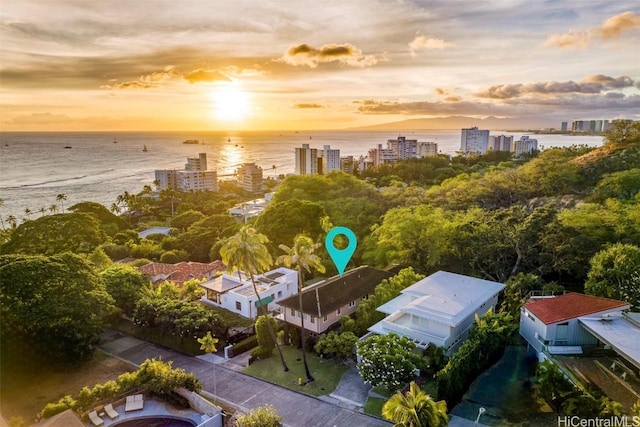 aerial view at dusk featuring a view of city and a water view