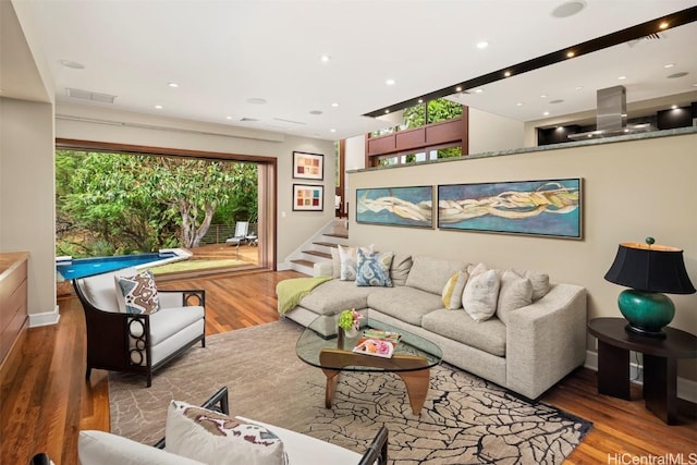 living room with visible vents, recessed lighting, stairway, and wood finished floors