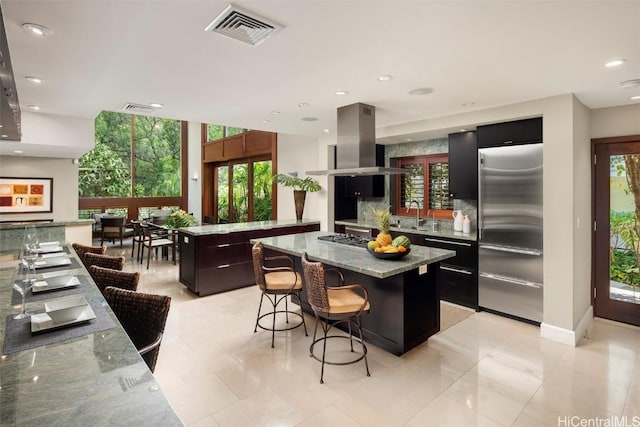 kitchen with tasteful backsplash, visible vents, a kitchen island, island exhaust hood, and stainless steel appliances