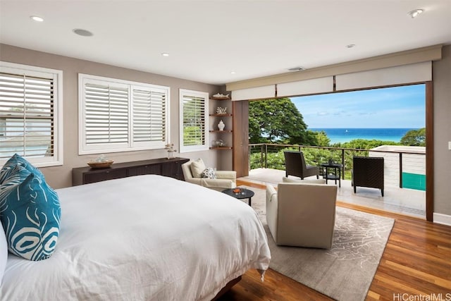 bedroom featuring visible vents, a water view, wood finished floors, recessed lighting, and access to exterior