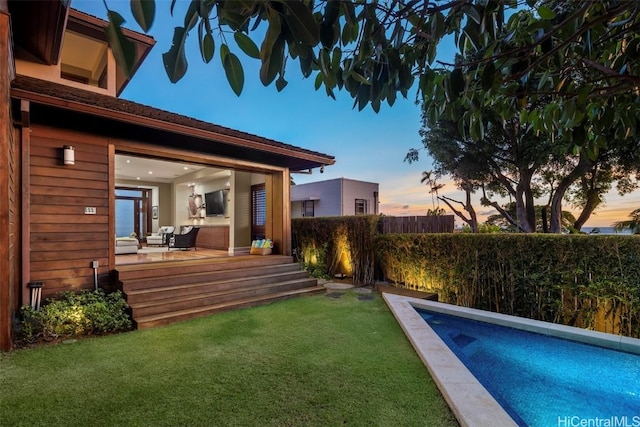 view of swimming pool with a lawn and fence