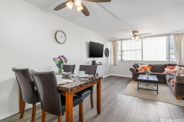 dining area with ceiling fan, baseboards, and wood finished floors