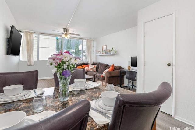 living room with a ceiling fan, light wood-style floors, and baseboards