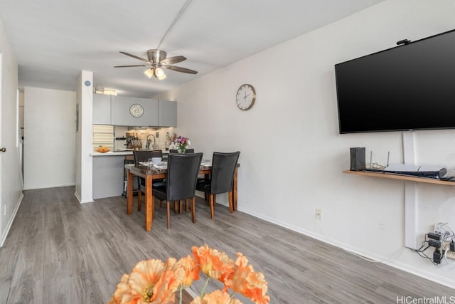 dining room with baseboards, ceiling fan, and wood finished floors