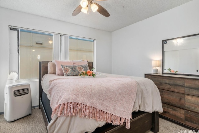 bedroom with a ceiling fan, carpet, and a textured ceiling