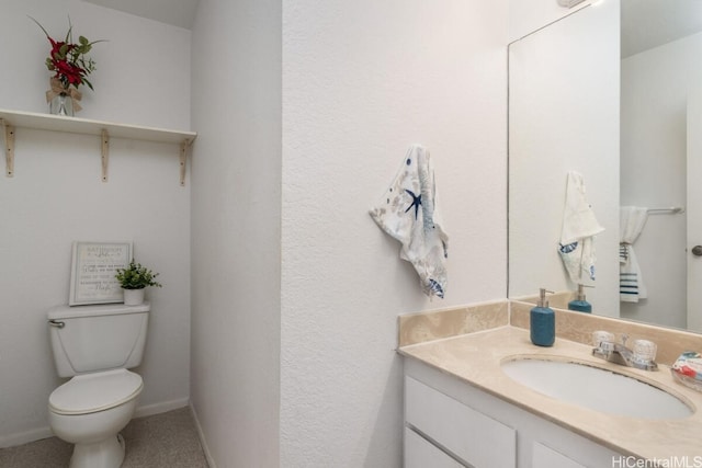 half bathroom with baseboards, toilet, and vanity