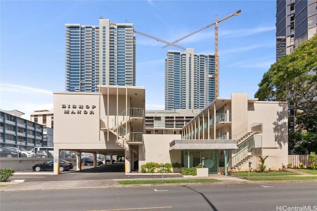 view of building exterior featuring a city view and uncovered parking