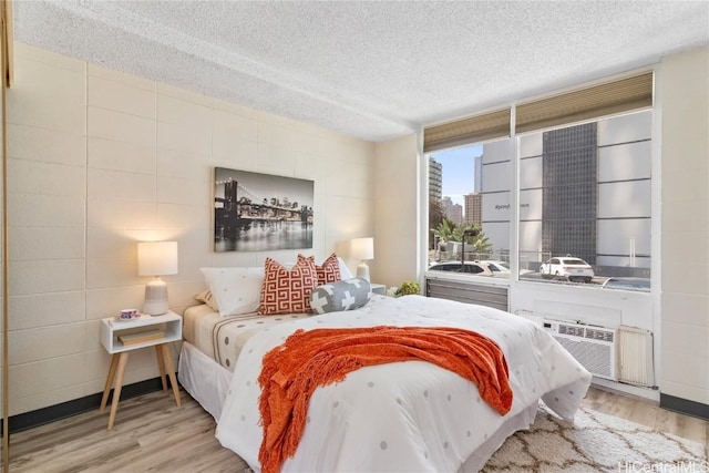 bedroom featuring a textured ceiling and light wood-style flooring