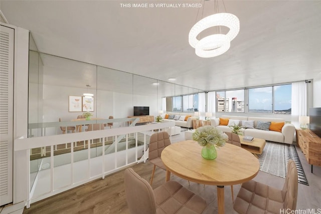 dining area with plenty of natural light, wood finished floors, and a chandelier