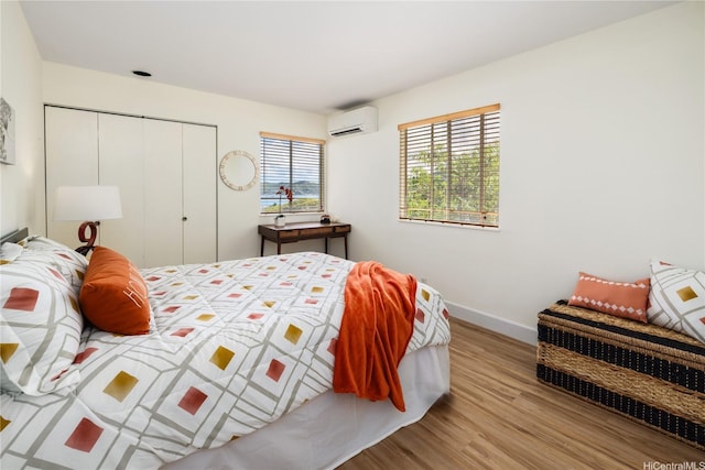 45-081 Lilipuna Rd Unit F, Kaneohe, HI 96744 - bedroom with wood finished floors, a wall unit AC, baseboards, and a closet