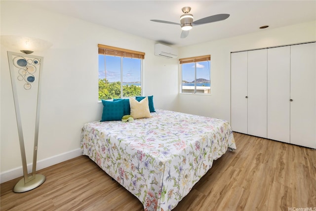 45-081 Lilipuna Rd Unit F, Kaneohe, HI 96744 - bedroom featuring an AC wall unit, wood finished floors, a closet, and baseboards
