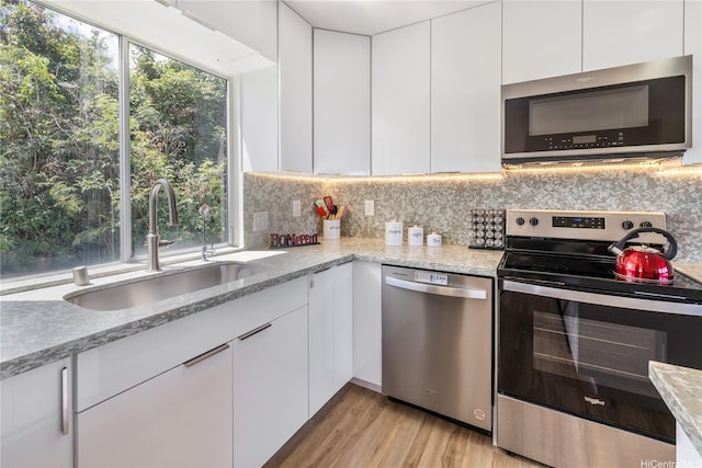 45-081 Lilipuna Rd Unit F, Kaneohe, HI 96744 - kitchen with stainless steel appliances, a sink, white cabinets, modern cabinets, and light stone counters