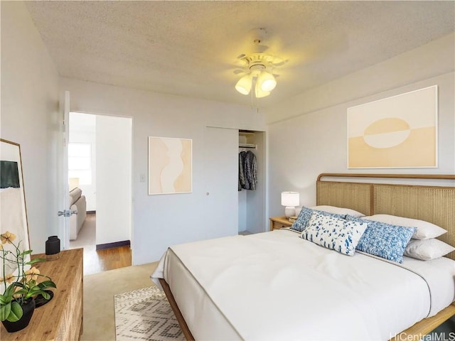 bedroom featuring ceiling fan, a closet, and a textured ceiling