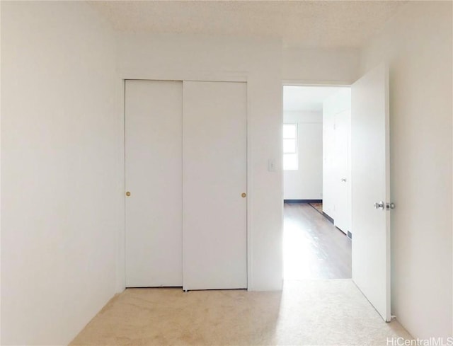 interior space with a closet, a textured ceiling, and carpet