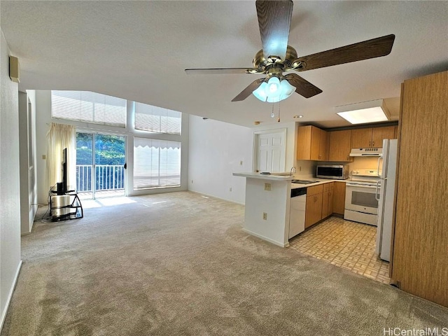 kitchen featuring light colored carpet, white appliances, a peninsula, and open floor plan