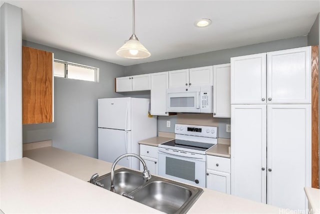 kitchen with white appliances, white cabinetry, light countertops, and a sink